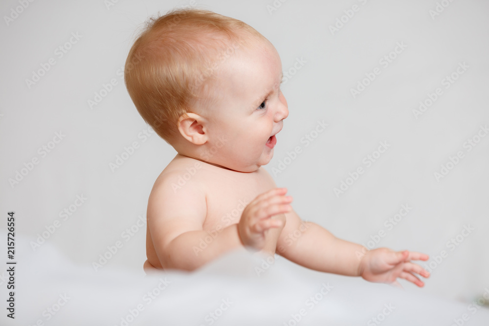 Adorable baby girl in white sunny bedroom. Newborn child relaxing in bed. Adorable baby girl in white sunny bedroom. Newborn child relaxing in bed.