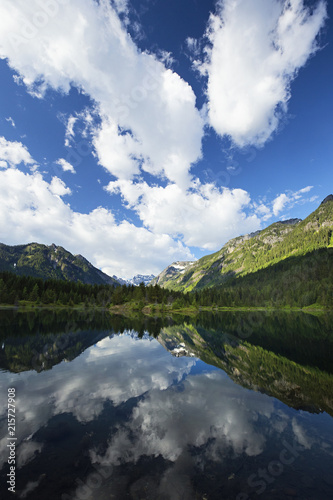 Fototapeta Naklejka Na Ścianę i Meble -  puffy clouds reflected in a mountain pond