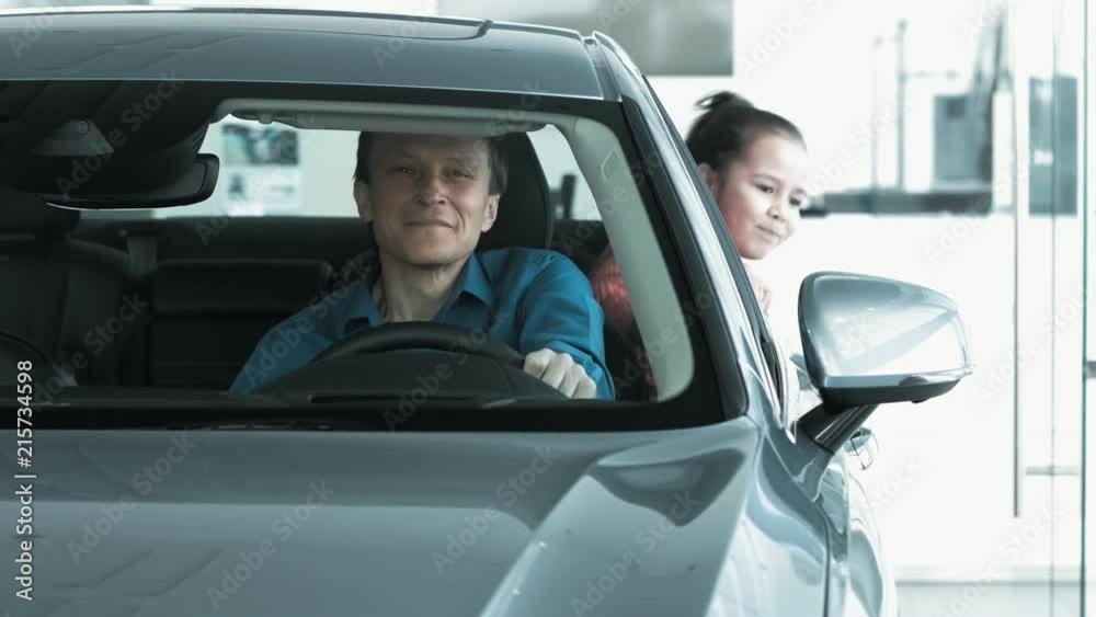 Men ls looking new car inside. Men ls looking new car inside.