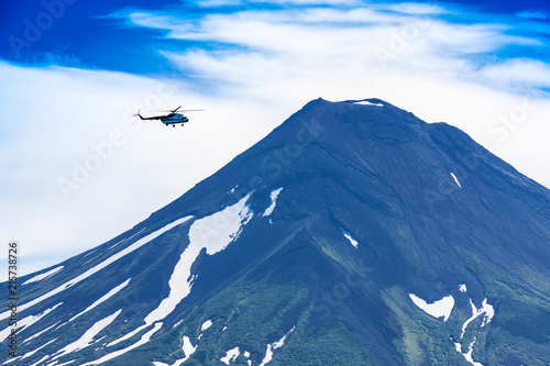 Helicopter flying over Ilyinsky Volcano and Kurile lake