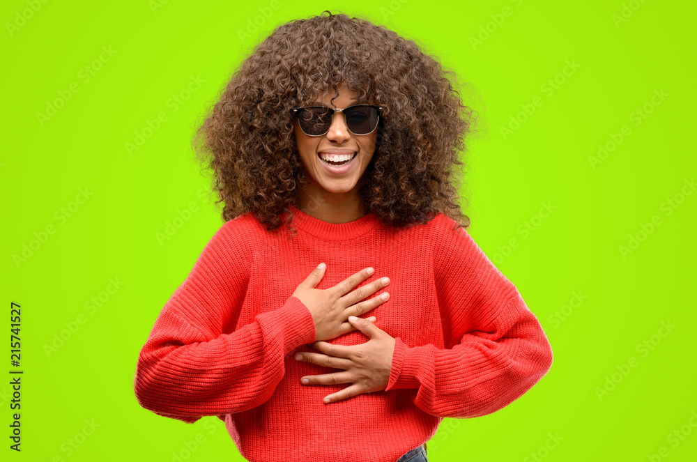 African american woman wearing sunglasses confident and happy with a big natural smile laughing African american woman wearing sunglasses confident and happy with a big natural smile laughing