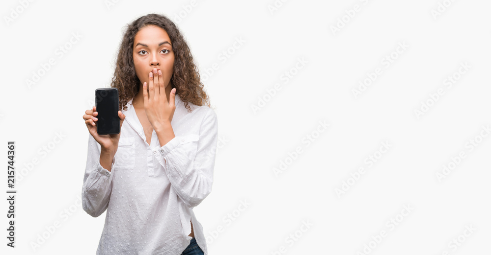 Young hispanic woman using smartphone cover mouth with hand shocked with shame for mistake, expression of fear, scared in silence, secret concept Young hispanic woman using smartphone cover mouth with hand shocked with shame for mistake, expression of fear, scared in silence, secret concept