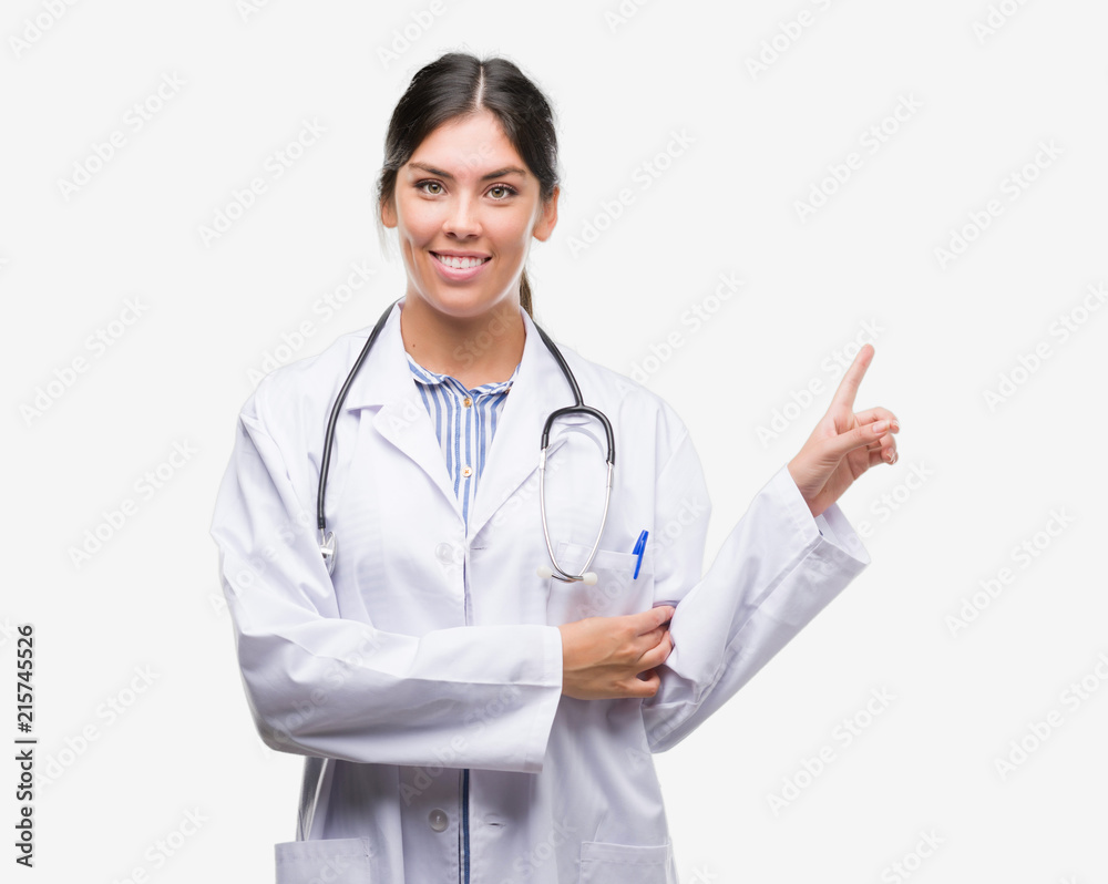 Young hispanic doctor woman very happy pointing with hand and finger to the side Young hispanic doctor woman very happy pointing with hand and finger to the side
