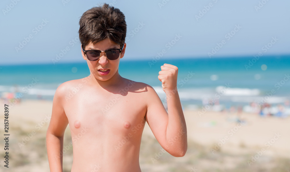 Young child on holidays at the beach annoyed and frustrated shouting with anger, crazy and yelling with raised hand, anger concept Young child on holidays at the beach annoyed and frustrated shouting with anger, crazy and yelling with raised hand, anger concept