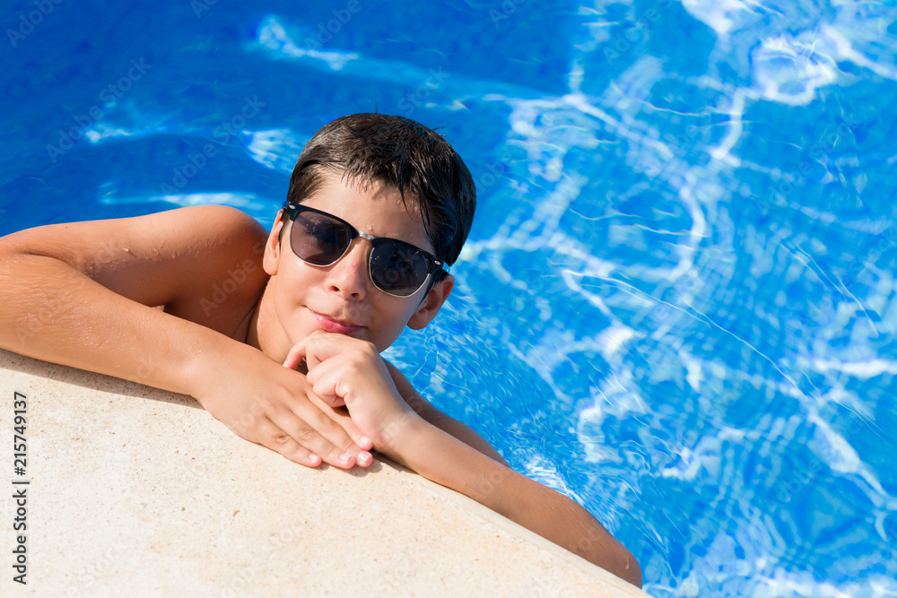 Young child on holiday at the swimming pool by the beach serious face thinking about question, very confused idea