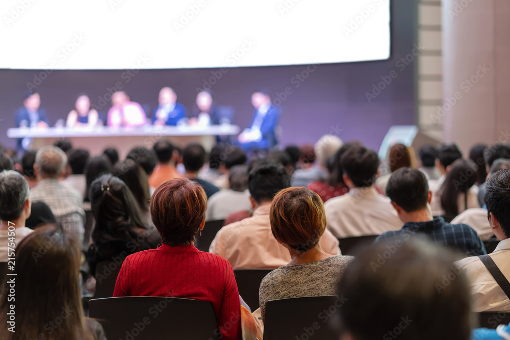 Rear view of Audience in the conference hall or seminar meeting which have Speakers are Brainstorming and talking on the stage, business and education about investment concept