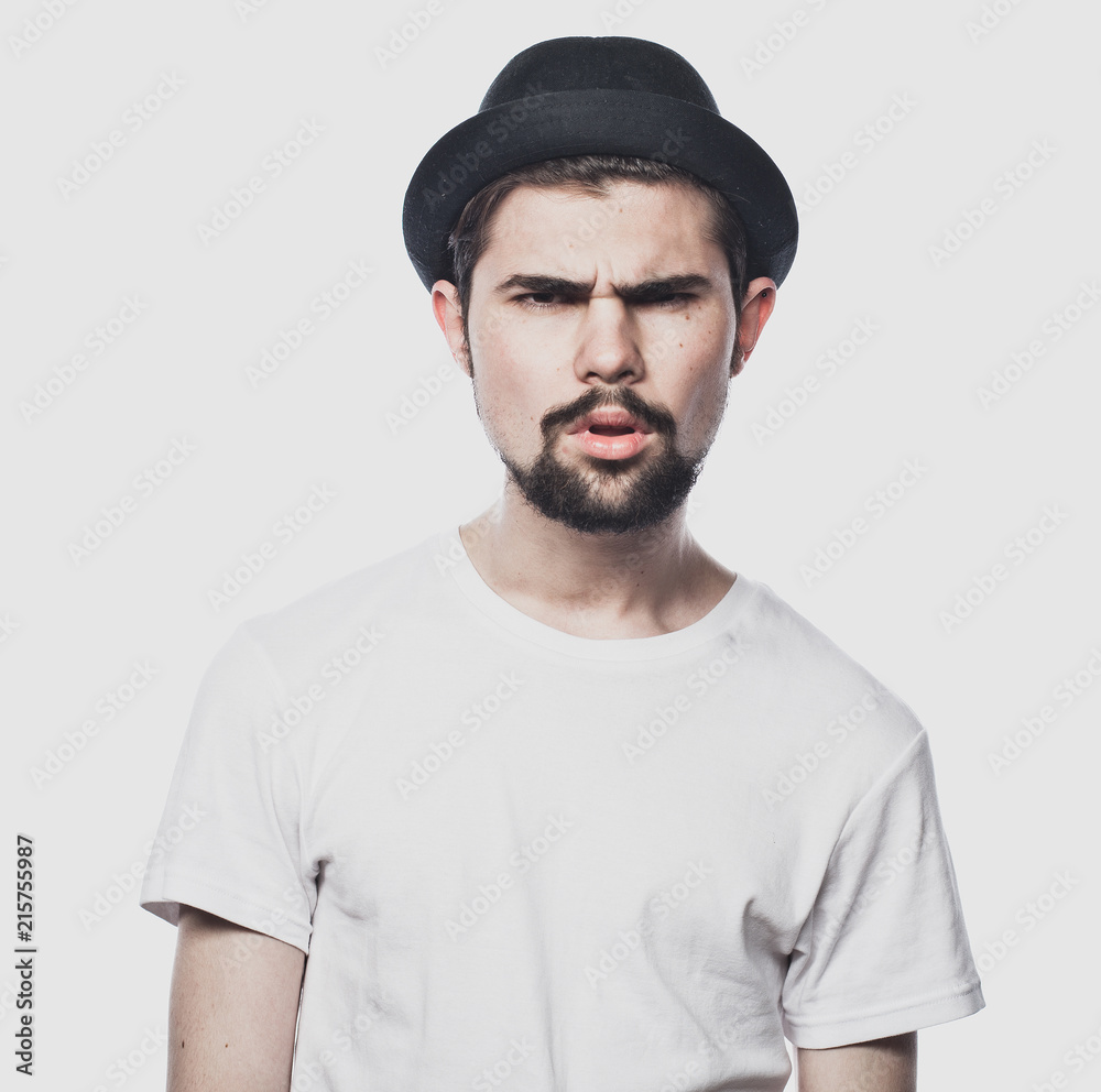 Portrait of bearded guy wearing black hat with unhappy expression on face Portrait of bearded guy wearing black hat with unhappy expression on face