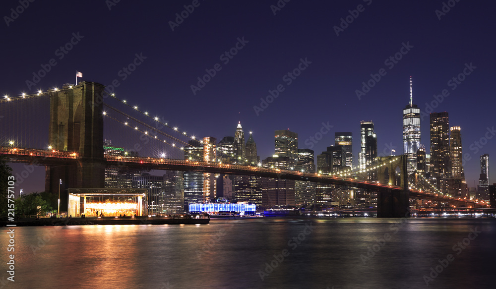 Panorama of Brooklyn Bridge and New York City (Lower Manhattan) with lights and reflections at dusk, USA