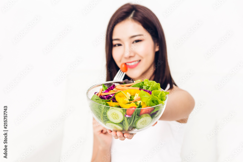 Happy woman eating and showing healthy fresh salad in a bowl.dieting concept.healthy lifestyle with green food Happy woman eating and showing healthy fresh salad in a bowl.dieting concept.healthy lifestyle with green food
