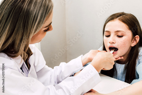 Doctor checking and examination in mouth with little girl child throat in hospital.healthcare and medicine