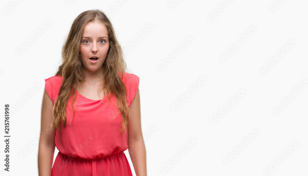 Young blonde woman wearing pink dress scared in shock with a surprise face, afraid and excited with fear expression Young blonde woman wearing pink dress scared in shock with a surprise face, afraid and excited with fear expression