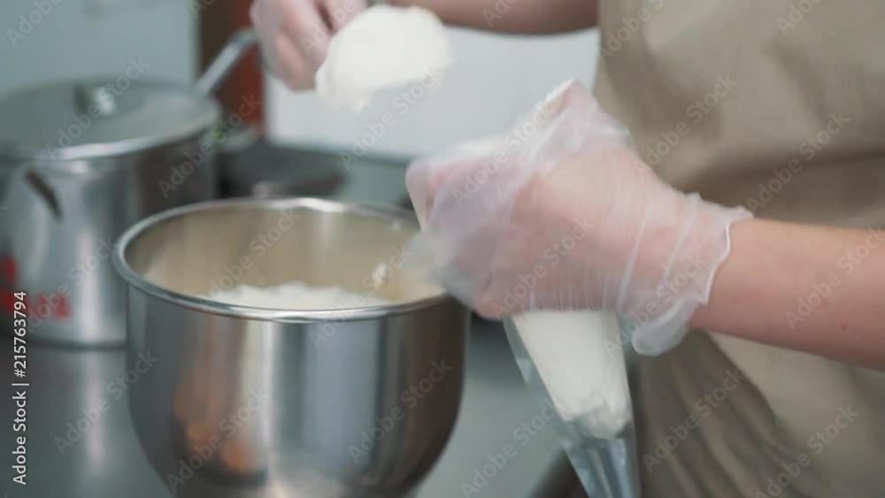 Decorating cup-cake with cream. Using cooking bag, confectioner making multicolor cupcakes for party. Shot of woman's hands putting butter cream on the tasty cakes, home bakery concept Decorating cup-cake with cream. Using cooking bag, confectioner making multicolor cupcakes for party. Shot of woman's hands putting butter cream on the tasty cakes, home bakery concept