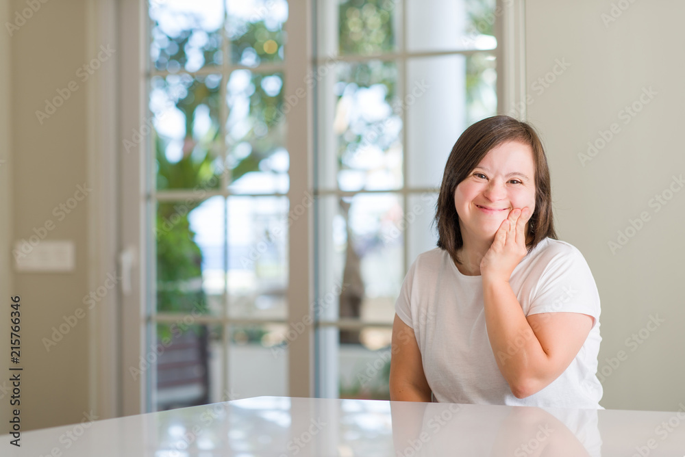 Down syndrome woman at home touching mouth with hand with painful expression because of toothache or dental illness on teeth. Dentist concept. Down syndrome woman at home touching mouth with hand with painful expression because of toothache or dental illness on teeth. Dentist concept.