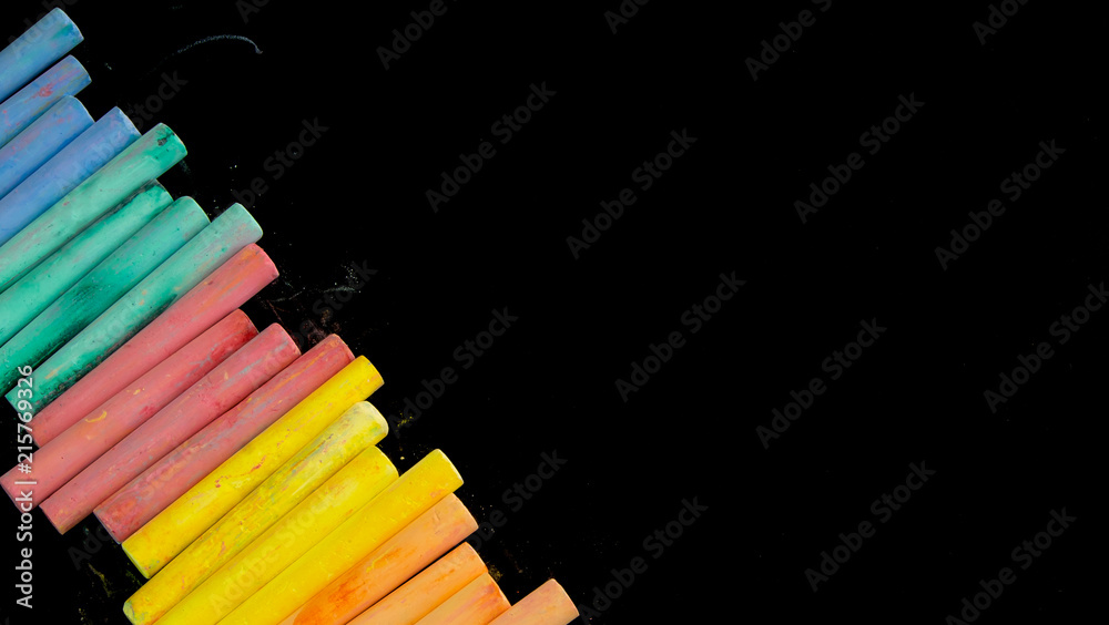 Obraz premium Multi color chalks on black background for copy space