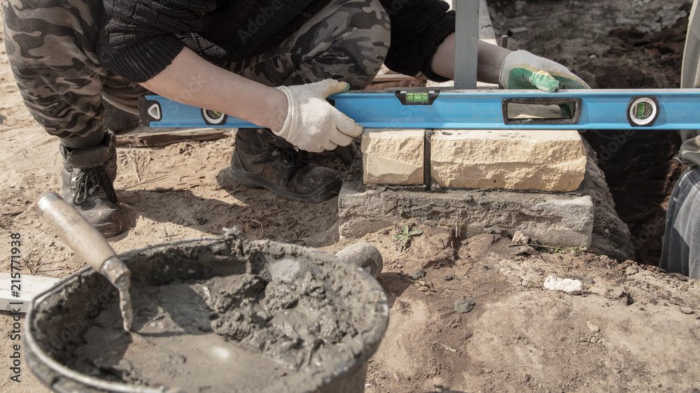 The worker lays bricks on the construction site The worker lays bricks on the construction site