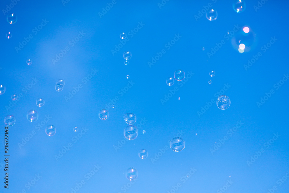 Soap bubbles in flight against the blue sky