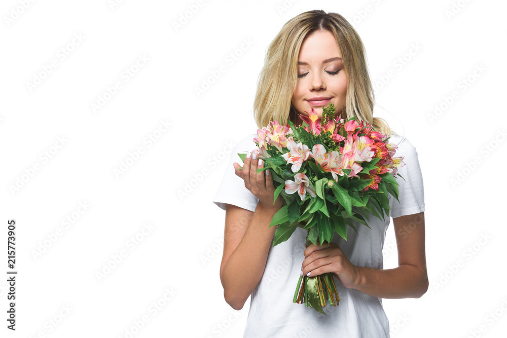 attractive girl in white shirt sniffing bouquet of flowers with closed eyes isolated on white