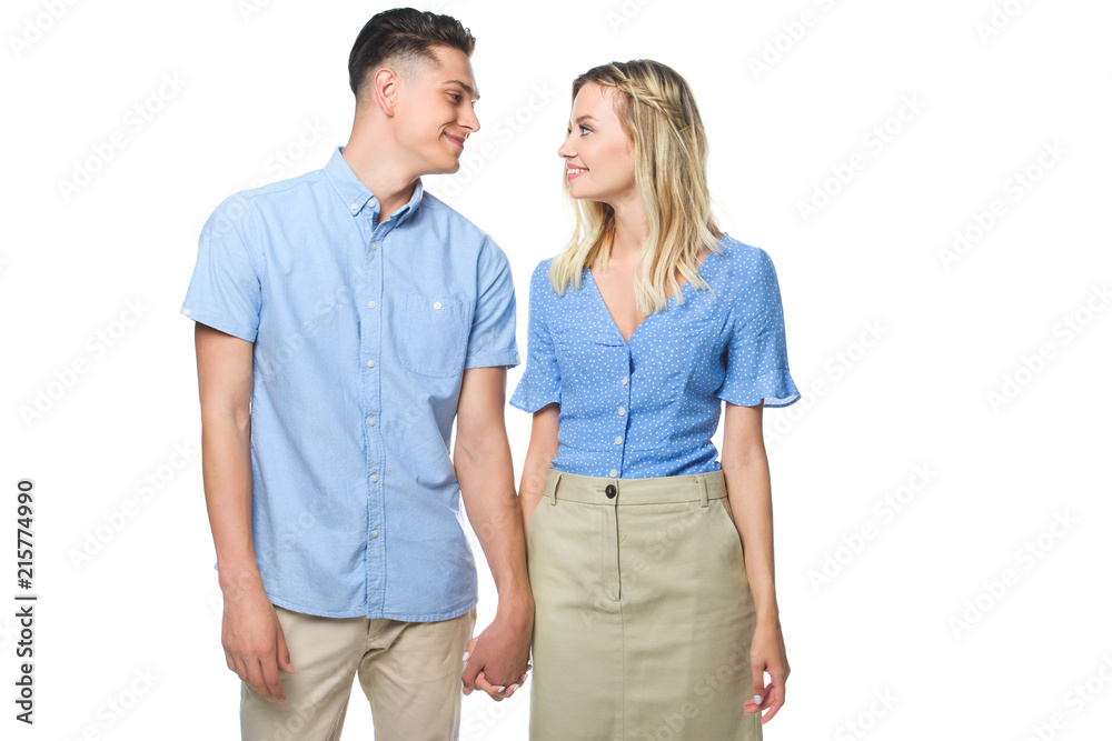 happy young couple holding hands and looking at each other isolated on white happy young couple holding hands and looking at each other isolated on white