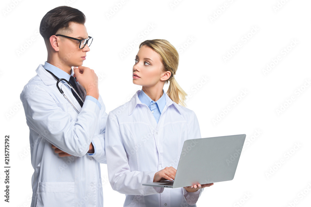 thoughtful doctors with laptop looking at each other, isolated on white thoughtful doctors with laptop looking at each other, isolated on white