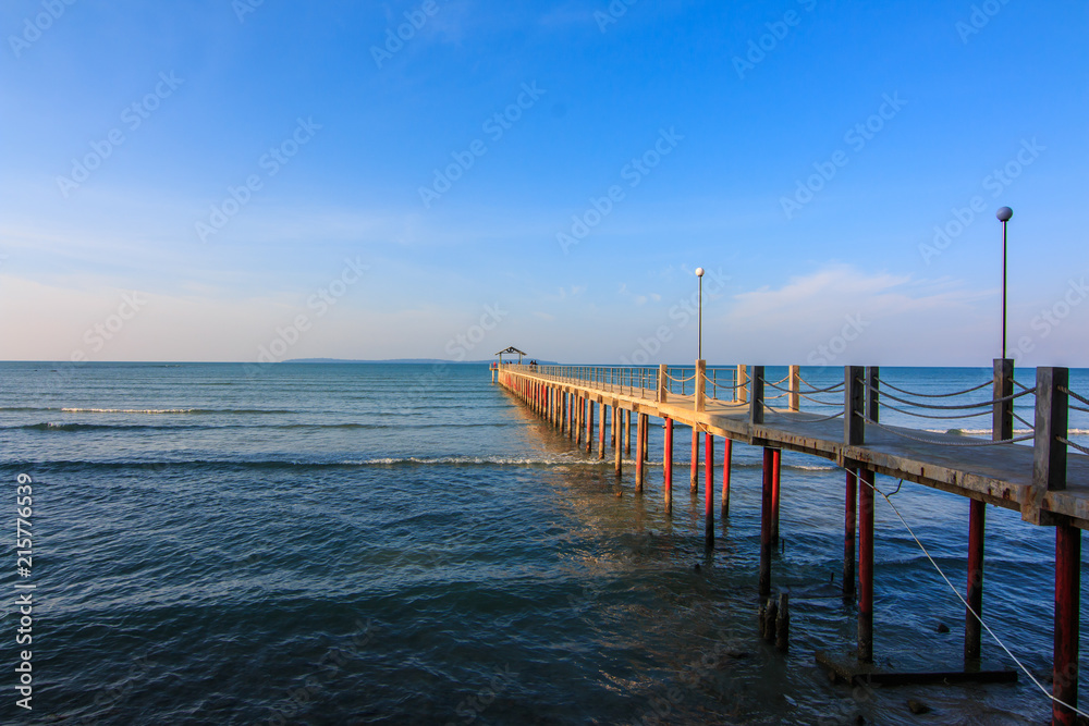 Concrete jetty into the sea on blue sky background