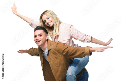 young happy woman piggybacking on boyfriends back and looking at camera isolated on white