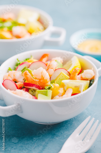 Salad with prawns in bowls on table