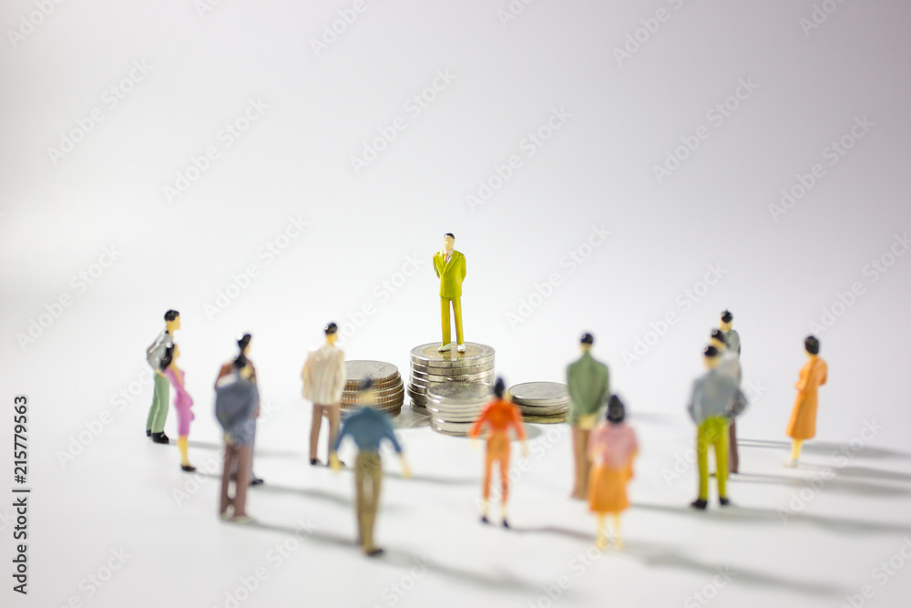 miniature businessman on stack of coins and miniature business people around it. miniature businessman on stack of coins and miniature business people around it.