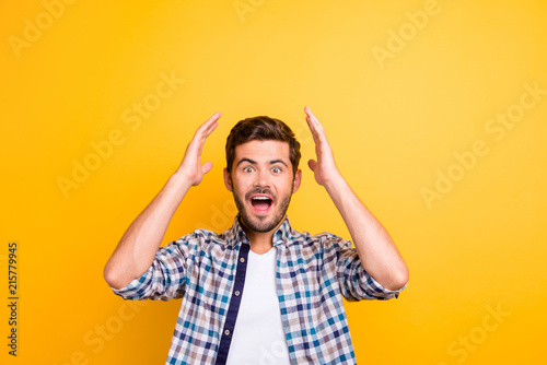 Close up of studio shot of glad man looks with surprise and amazement face, doesn`t expect to be a winner isolated on vivid yellow background photo