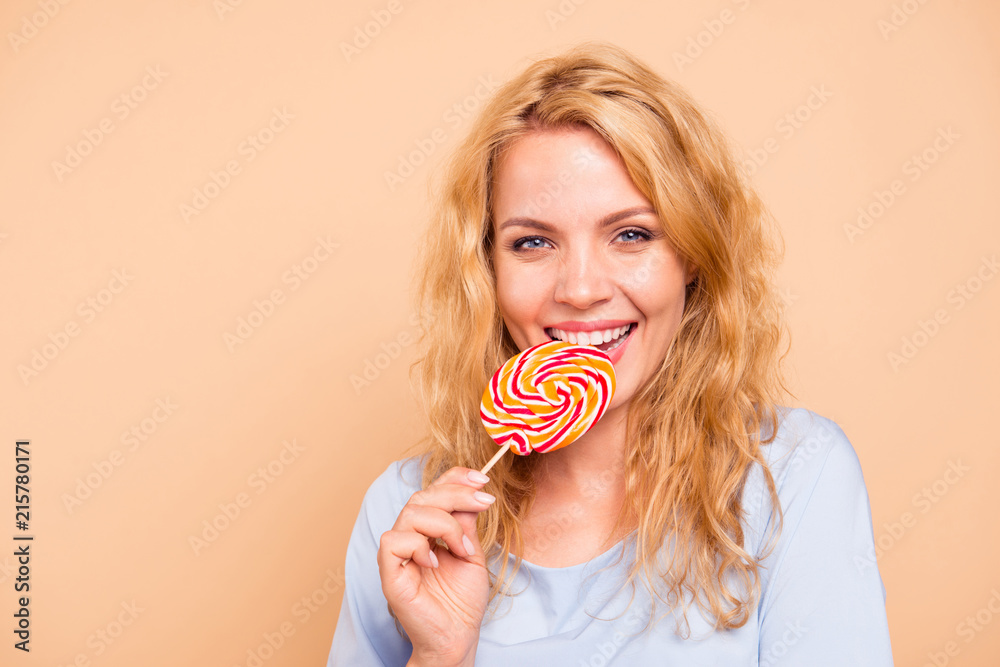 Yummy dessert! Close up photo portrait of pretty cheerful joyful lady tasting sweet colorful candy on stick in hand isolated on bright vivid color background copy space
