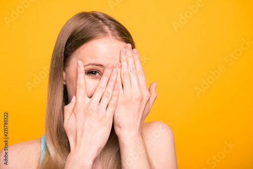 Canvas Print Close up portrait of young model woman close her eyes with palms, peeking out op
