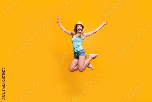 Full-size portrait of sweet young woman in hat jump and laugh fun isolated on shine yellow background with place for text © deagreez