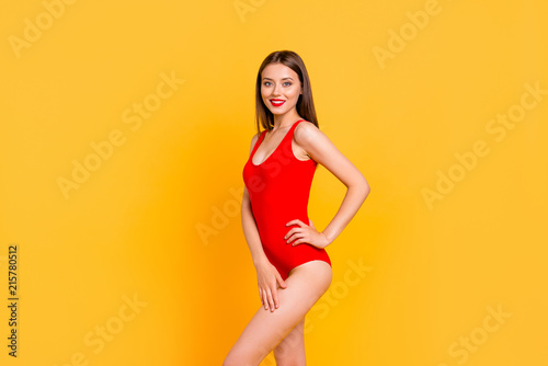 Charming young brunett girl with big smile looking at camera and stand in half turn isolated on vivid yellow background with copy space