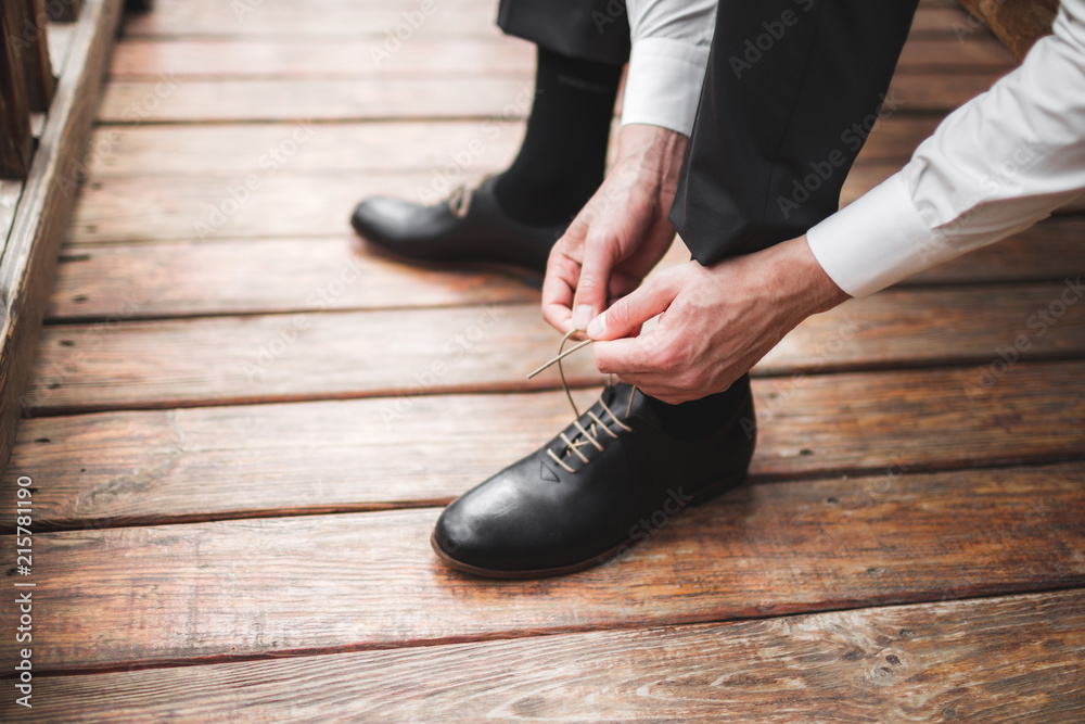 Man wearing brown leather classic shoes, black trousers and white shirt, business style