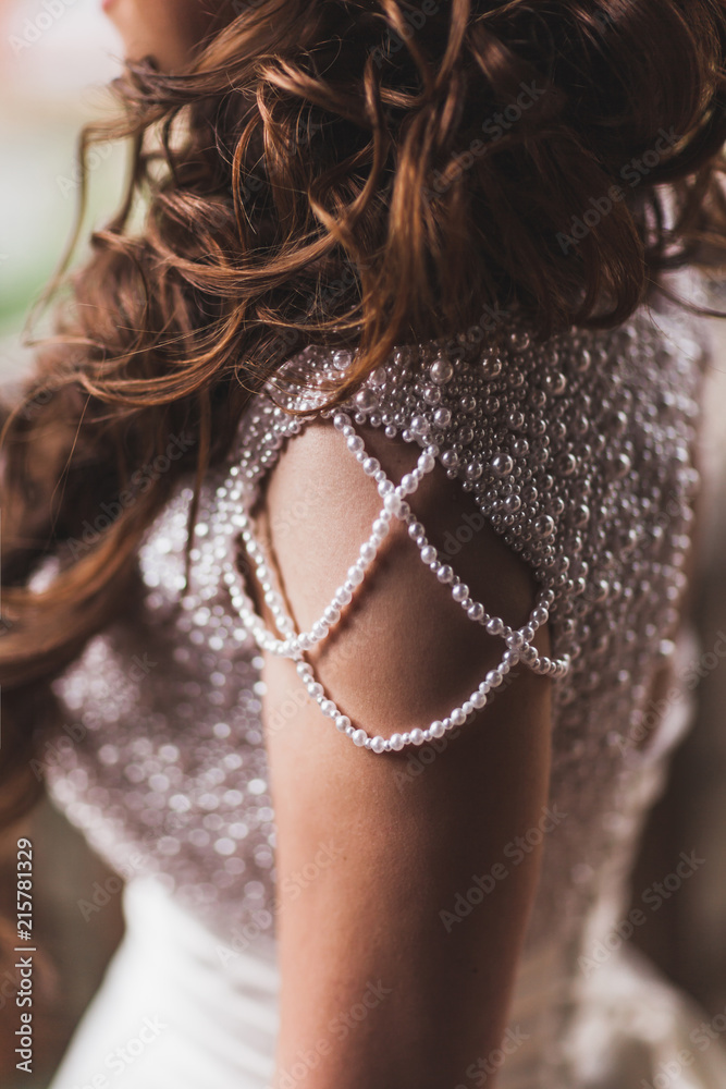 Details of shining wedding dress with pearls and gemstones closeup