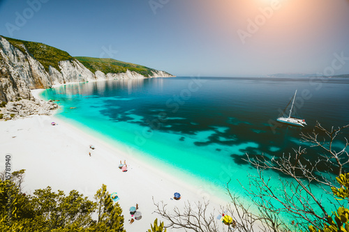 Fototapeta Naklejka Na Ścianę i Meble -  Paradise beach with clear azure emerald sea water surrounded by high white rocky cliffs. Fteri beach in Kefalonia Island, Greece