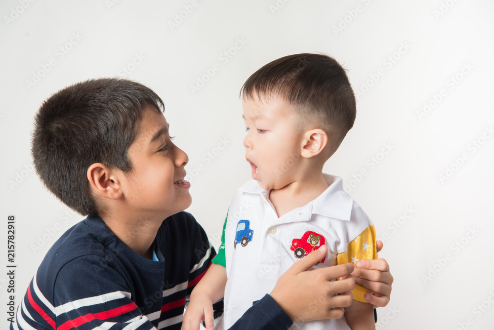 Little sibling boy brothers checking there high  tall each other