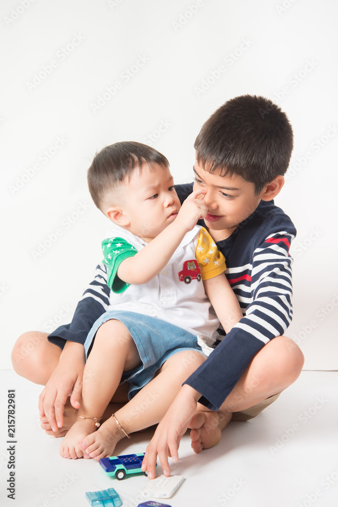 Little sibling boy brothers checking there high tall each other Little sibling boy brothers checking there high tall each other