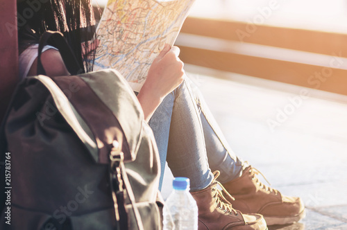 Tourist travel woman looking at the map while walking on a street  - street backpack travel concept