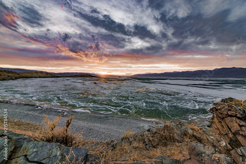 Scenic view of frozen wild lake under stormy sky 