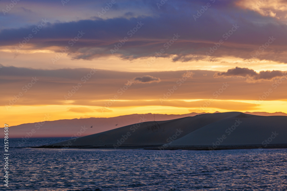 Scenic view of lake with mountains on horizon at sunset
