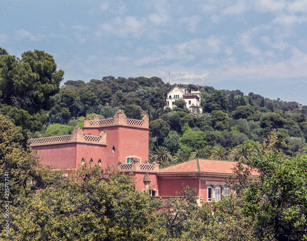 Obraz premium Red eighteenth century building of Baldiri Reixac school (former farmhouse residence of Count Guell), named Casa Larrard, and white Casa Trias in Park Guell, Barcelona, Spain.