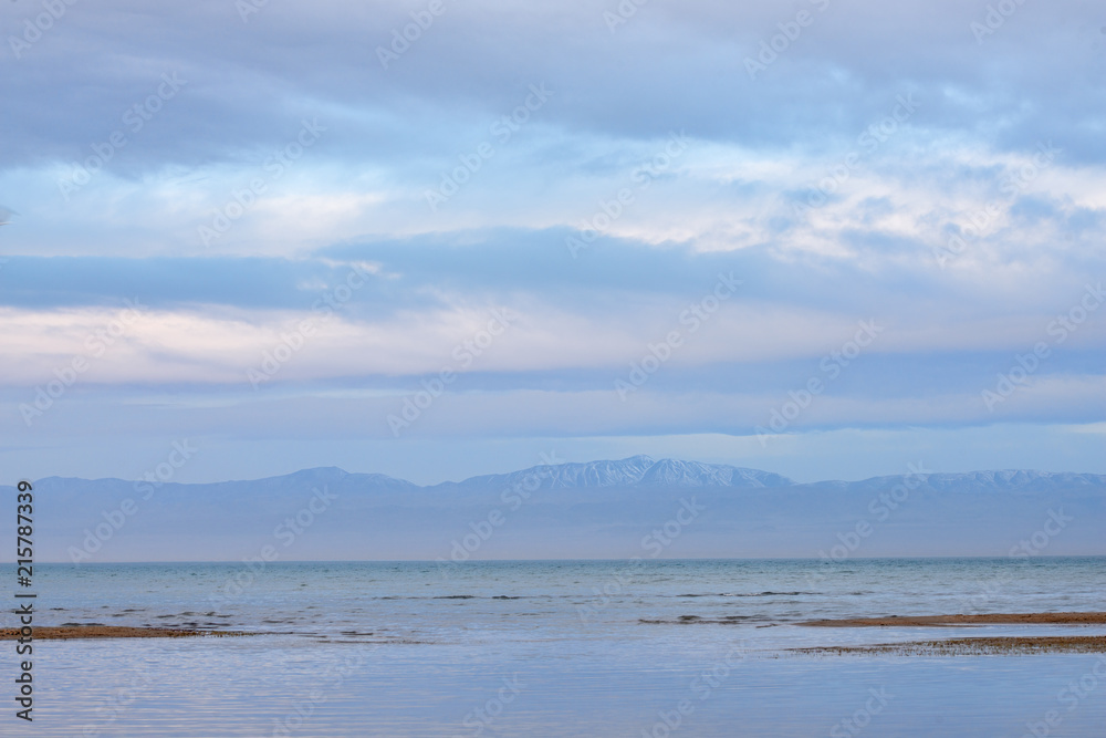 Scenic view of lake with grey mountains on horizon
Scenic view of lake with grey mountains on horizon