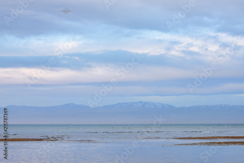 Scenic view of lake with grey mountains on horizon 