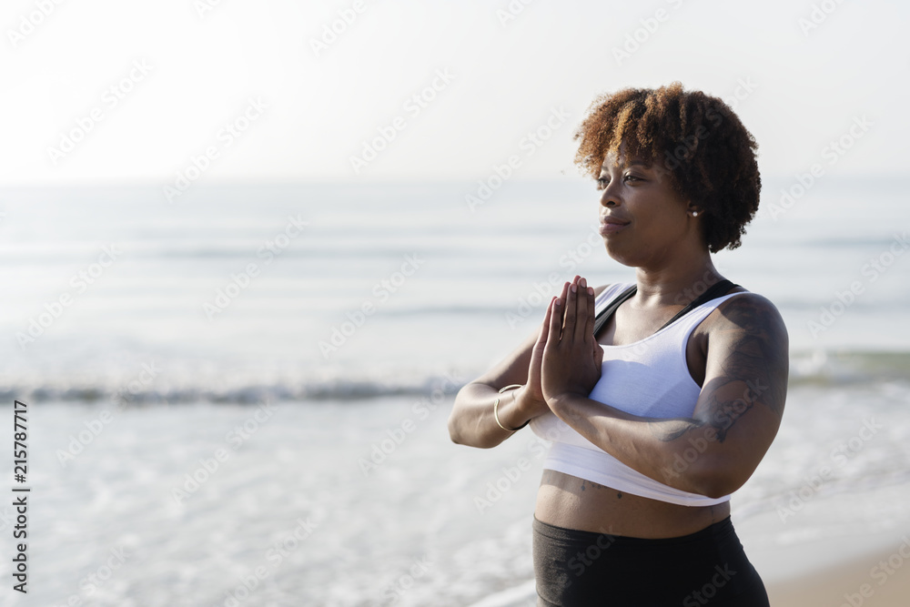 African American woman practicing yoga at the beach - obrazy, fototapety, plakaty 
