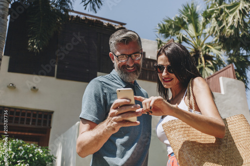 Couple using their phone while on vacation photo