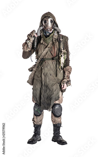 Terrifying post apocalyptic human creature, person survived in poisoned by pollution, post nuclear catastrophe world wearing tatters and full-face gas mask isolated on white background studio shoot