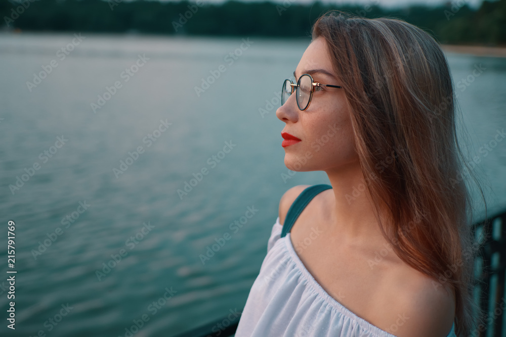 Attractive girl wearing glasses on park lake view