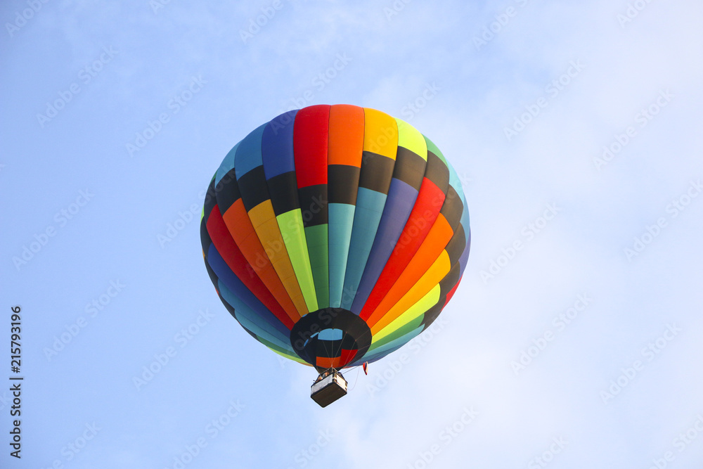 colorful hot air balloon against blue sky. hot air balloon is flying in white clouds. beautiful flying on hot air balloon colorful hot air balloon against blue sky. hot air balloon is flying in white clouds. beautiful flying on hot air balloon
