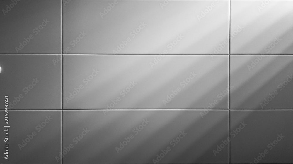 Background White tiles wall with a light shines.