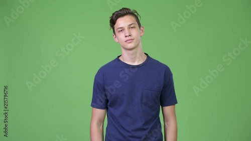 Young handsome teenage boy looking bored